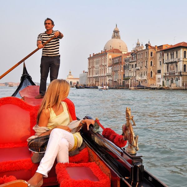 \u200bAn Italian gondolier navigates a tourist through Venice on the Grand Channel.
