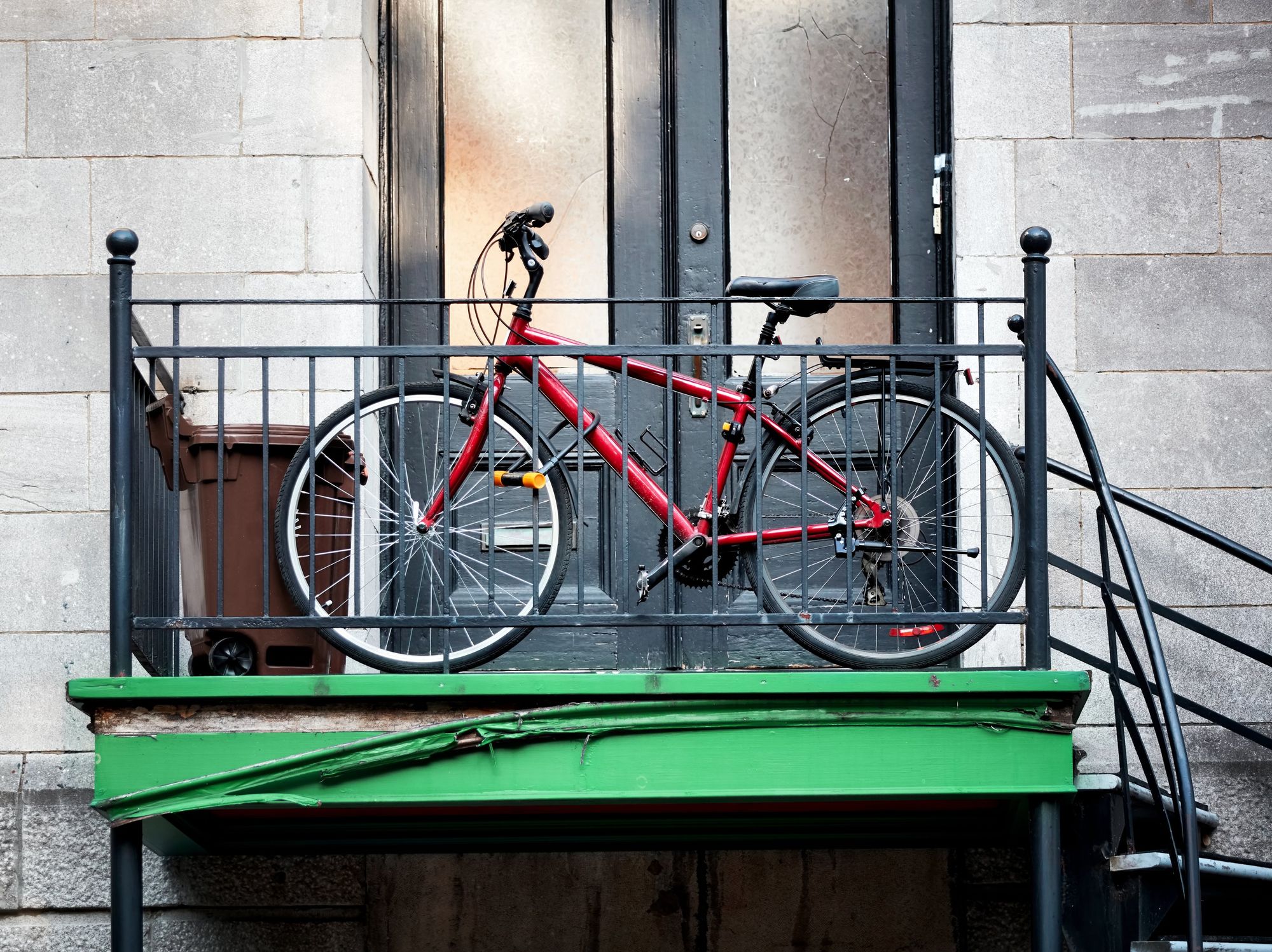 \u200bBike in front of a Montreal apartment door at the top of a staircase.