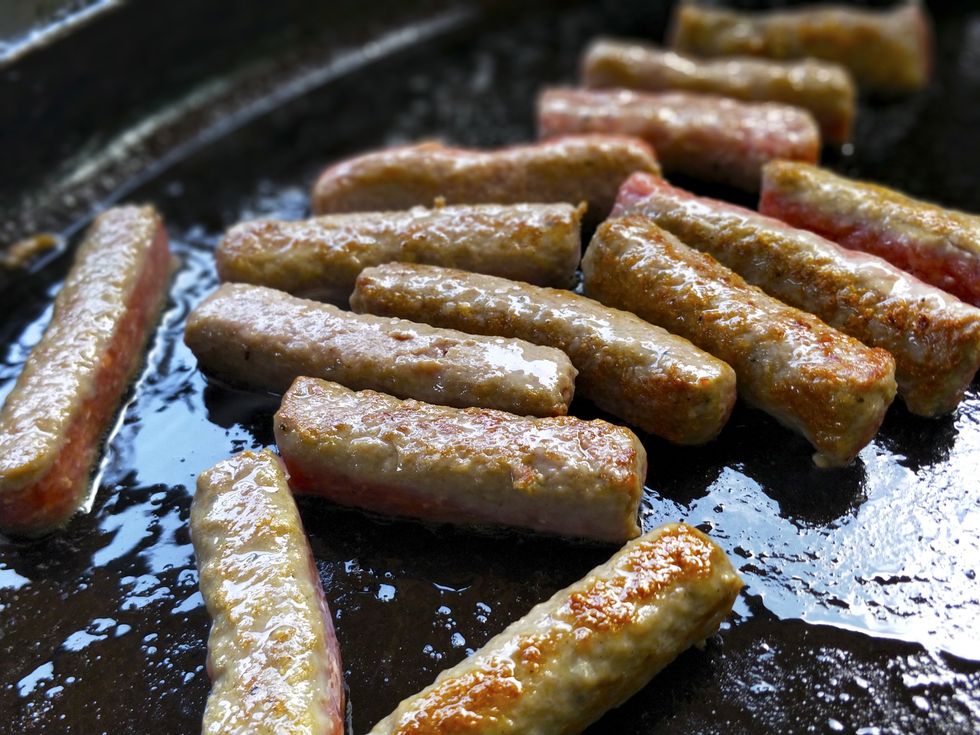 \u200bGeneric breakfast sausages cooking in a pan.