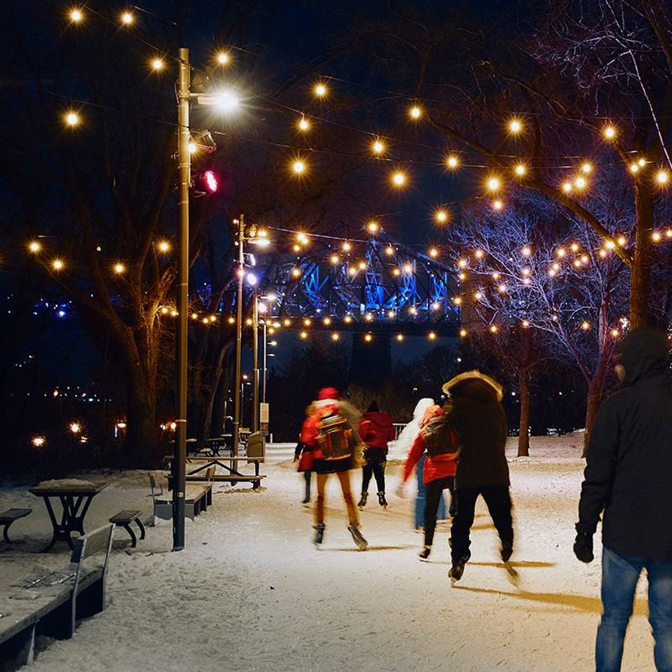 \u200bPeople skating under string lights.