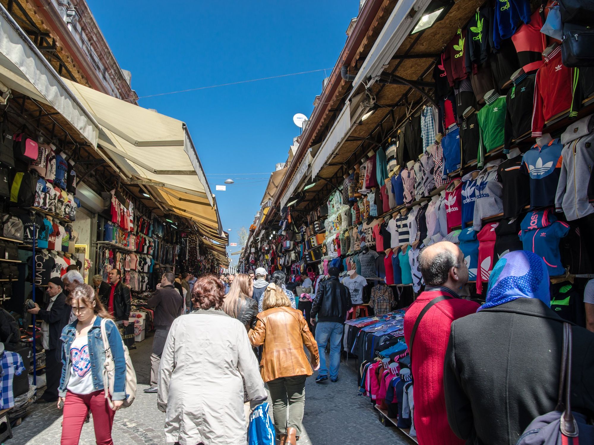 \u200bPeople walk down an alley lined with shops at a market in Istanbul.