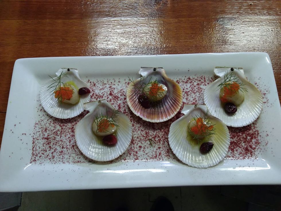 \u200bSeashells filled with seared scallops in cranberry seed oil, tobiko caviar and organic fennel from the herb garden.