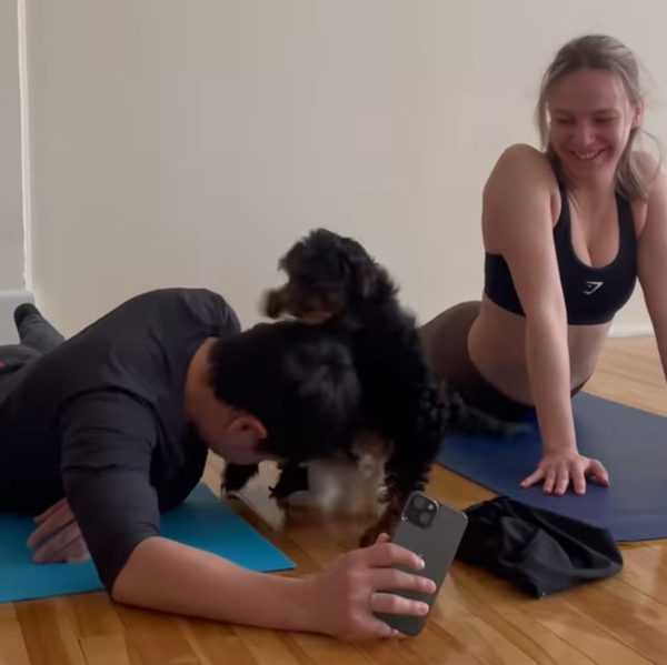 \u200bSomeone holding a phone is ambushed by puppies next to another person holding a yoga pose.