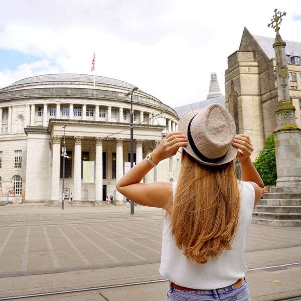 \u200bSomeone holds onto their hat in St. Peter's Square in Manchester.