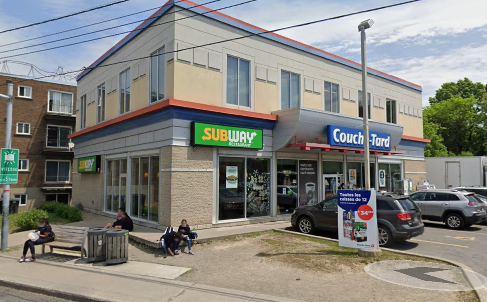 \u200bThe exterior of a Subway sandwich shop in Montreal directly beside a busy bus stop and Couche-Tard corner store.