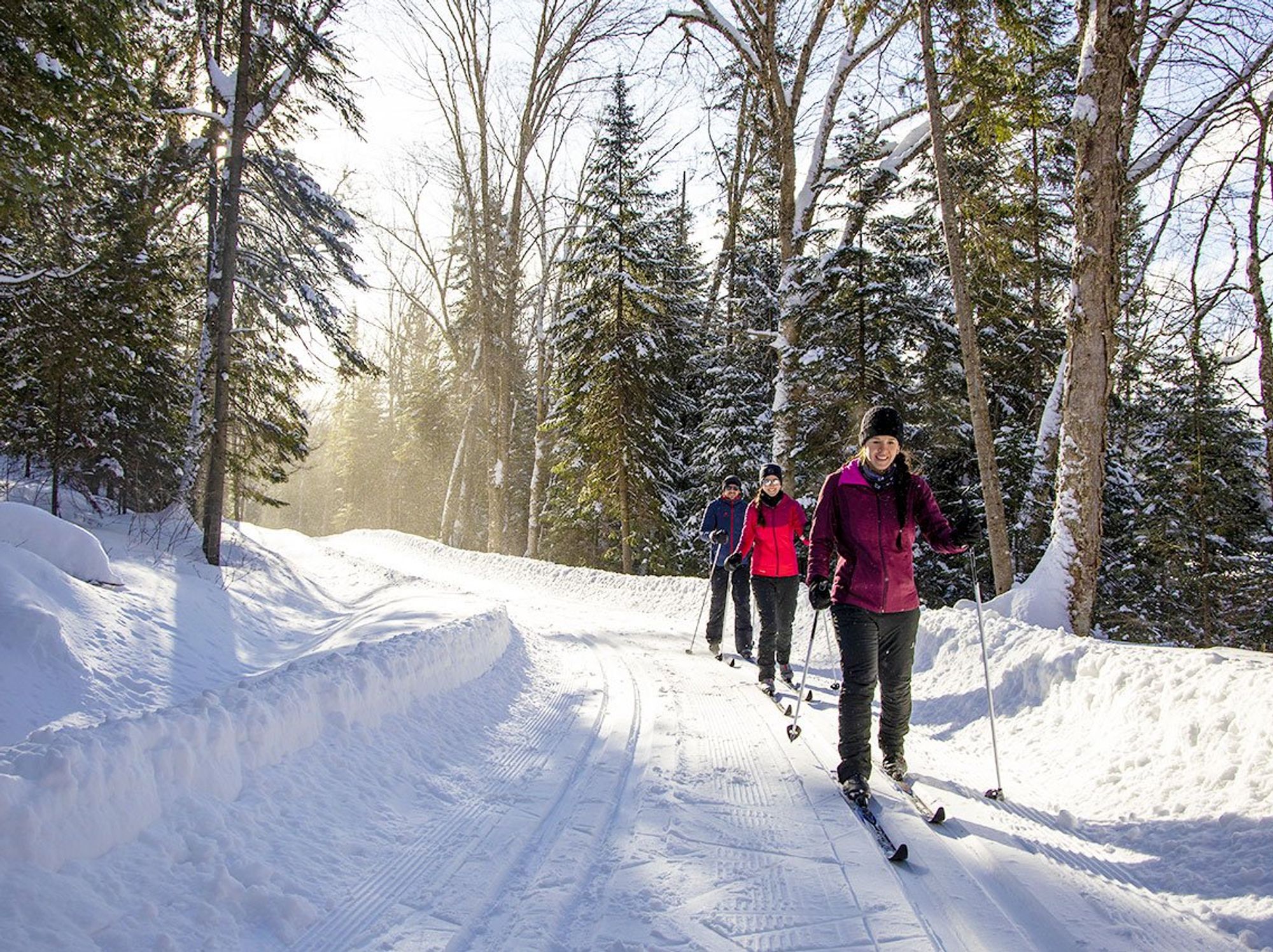\u200bThree people on a cross country ski path.