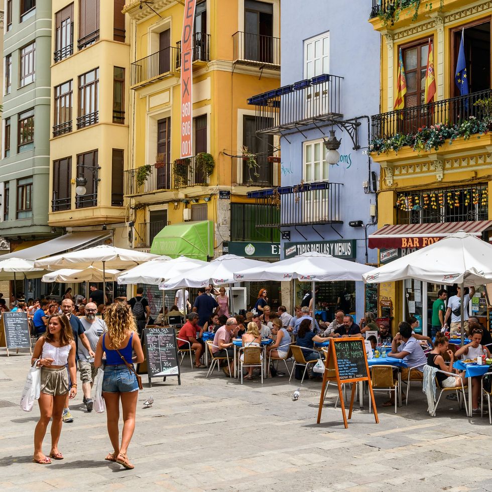 \u200bTourists have lunch at outdoor restaurants in Valencia's Mercat Central.