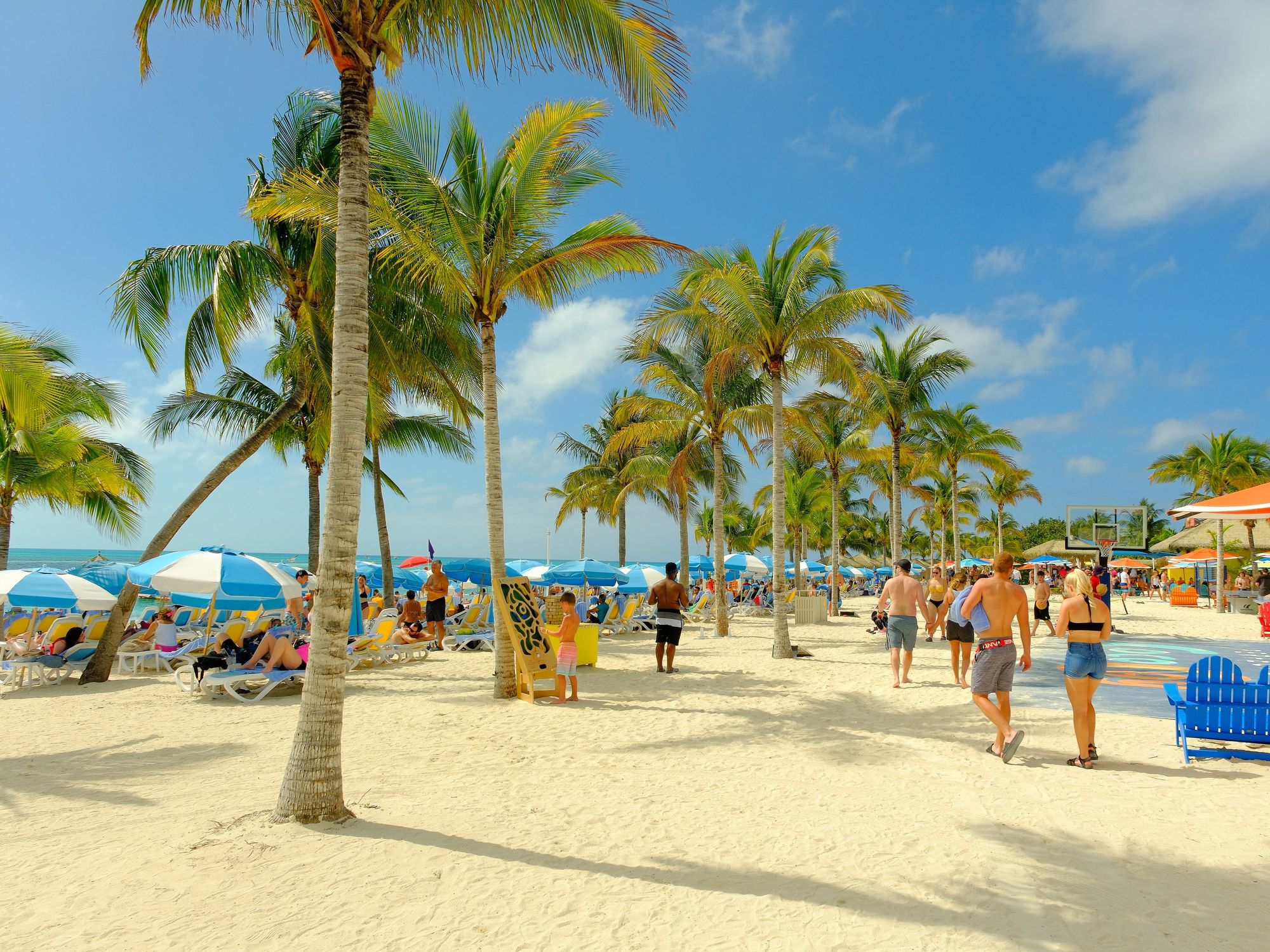 \u200bTourists walk on the beach at Cococay in the Bahamas.