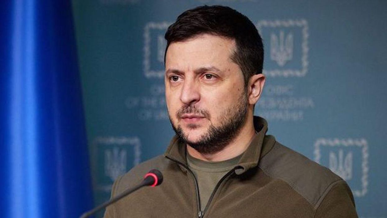 Ukrainian President Volodymyr Zelensky speaking at a podium with a Ukrainian flag in the background.