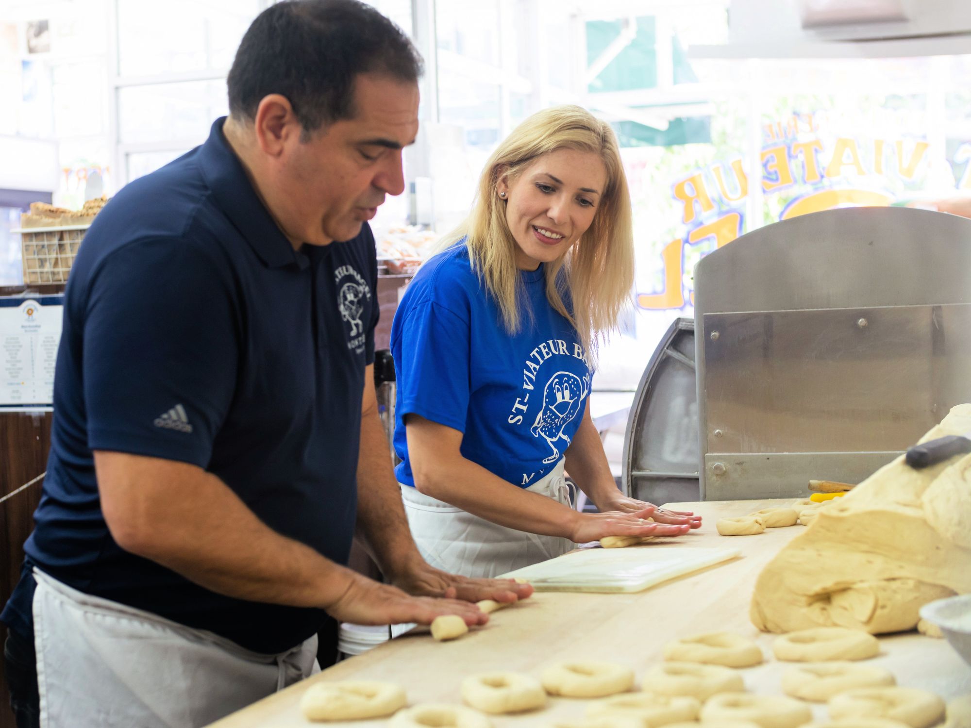 Vince Morena showing Sofia how to shape the dough.