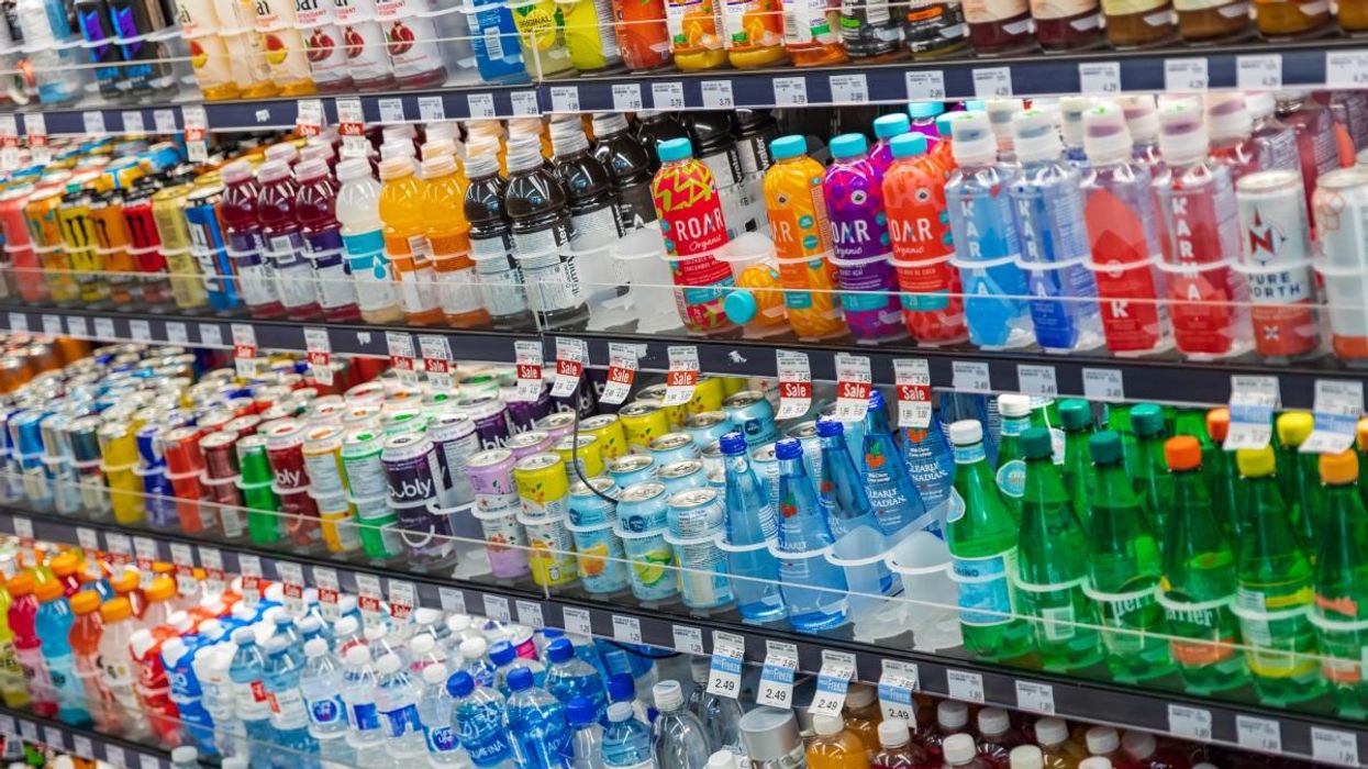 Water bottles, juice and flavoured beverages in a refrigerator at the grocery store.